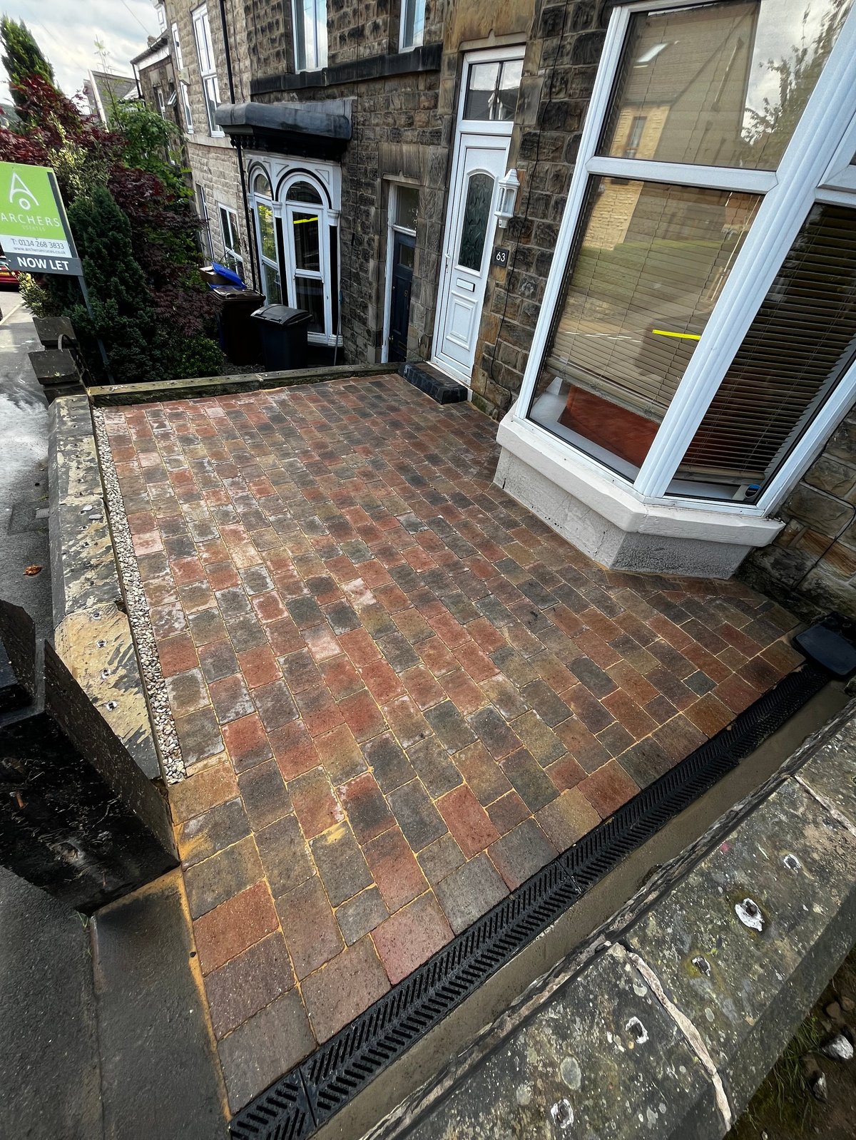 Red brick paving finished front entrance of stone terraced house after transformation